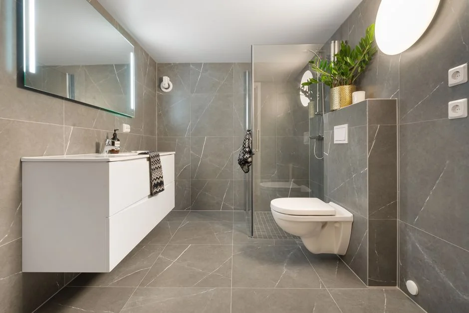 From above anonymous housekeeper in yellow rubber gloves spraying cleaner to chrome water faucet in bathroom